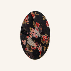 Abstract charming easter minimal concept. Black textile with flowers design on it, egg shaped against of white background