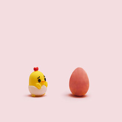 Awesome minimal Easter concept.  Little chick toy with one red egg arrangement with creative copy space. Pastel pink background.
