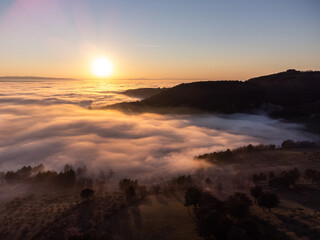 Drone view of Umbria valley Italy above a sea of fog at sunset
