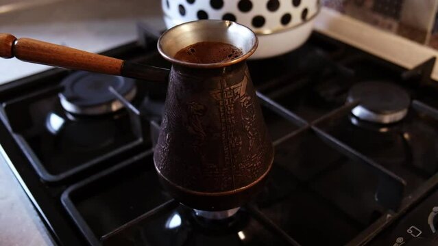 coffee is brewed in a ibrik on gas stove. Slow motion video Full HD