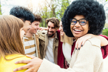 Happy multiracial friends hugging together outside - International students having fun in college campus - Young people support community
