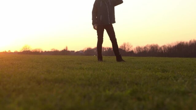 Happy family at sunset. Silhouette of group of people walk in park. child with parents holding hand. Father playing football game on grass. Young Dad fave fun do sport with children siblings outside