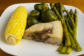 sword fish  with  brussel  sprouts  , asparagus and corn