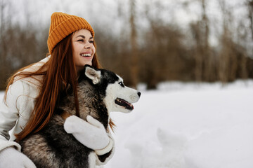 cheerful woman winter clothes walking the dog in the snow Lifestyle