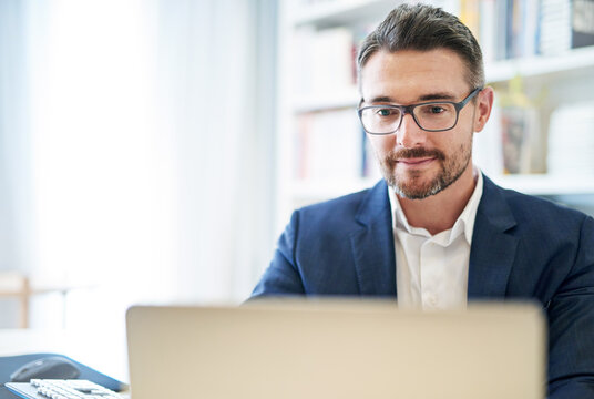 Getting things done through technology. Shot of a mature businessman working at his computer in an office.