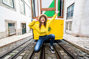 Woman tourist with famous yellow funicular tram of Lisbon, Portugal - Tourist attraction - Europe...