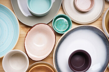 Dishes for serving and eating meals on a wooden background, top view. Modern ceramic and wooden...