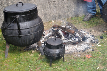 Potes de comida cozinhada numa fogueira ao lume, ar livre - montanha