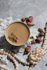 Obraz na płótnie Canvas Cup of tea with milk and roses. Tea in beautiful vintage cup. Close up photo of hot aromatic beverage. 