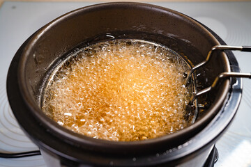 top view. oil boiling in deep fryer. in fryer cook shrimp in batter or potatoes.