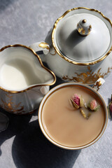 Obraz na płótnie Canvas Vintage sugar bowl, milk jug and beautiful on light grey background. Shadows on a table. Close up photo of retro ceramic tableware. 