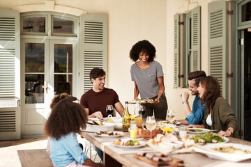 Love, family and laughter. Shot of a group of people sharing a meal.
