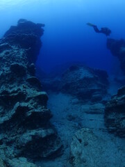 Fototapeta na wymiar Scuba divers exploring the bid strange rocks underwater topography