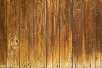 Obraz premium Authentic natural brown wood background with orange undertones. Old boards with a natural gradient on the surface from light to dark brown.