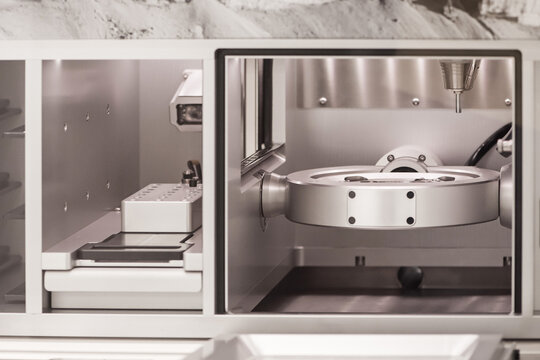 Cad cam milling machine in dental laboratory. Production of high esthetic dental crowns and dentures.