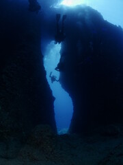 cave diving underwater scuba divers exploring caves and having fun ocean scenery sun beams and rays background