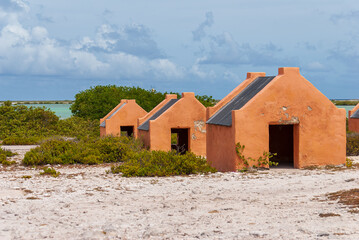 Multiple historic red slave hut sin Bonaire, Caribbean