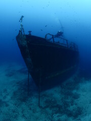 scuba divers exploring shipwreck scenery underwater ship wreck deep blue water ocean scenery of metal underwater