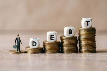 Block word debt on pile of coins with business man, Payment of taxes and of debt to the state,...