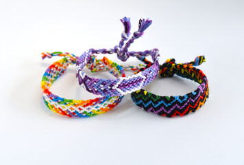 Tied woven friendship bracelets with bright colorful pattern handmade of thread isolated on white background