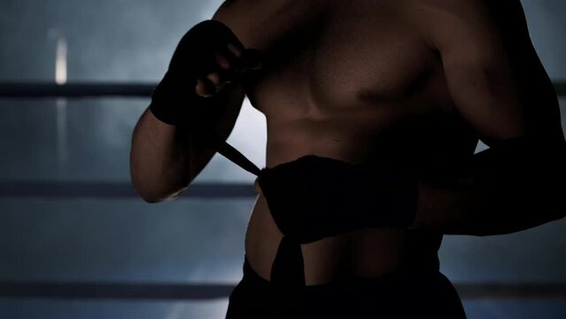  Fighter wraps his hands with boxing bandages, kickboxing training day in a gym. High quality 4k footage