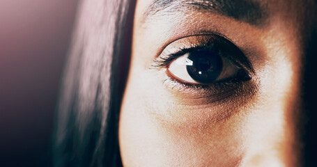 Hidden in plain sight. Closeup shot of a beautiful young womans eye against a dark background. © Marco v.d Merwe/peopleimages.com