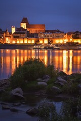 Beautiful urban night landscape. The old buildings of the Polish city of Toruń on the Vistula River.