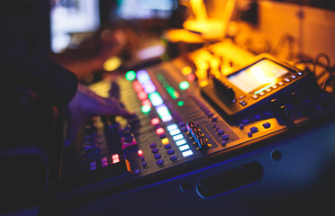 View of lighting technician operator working on mixing console workplace during live event concert...