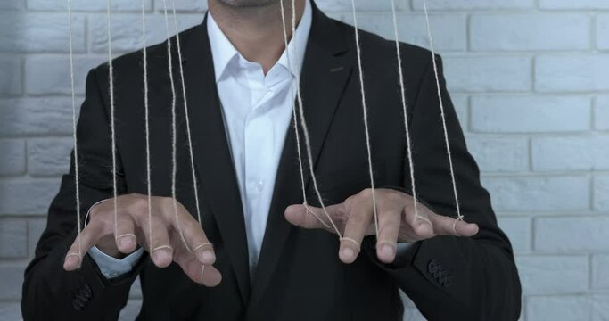 Affect a person. A view of a person with strings on his fingers in the room.