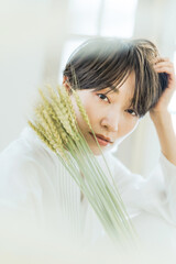 Naklejka premium 麦の稲穂を持った女性 収穫 豊穣