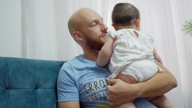 young latin man father holding and comforting his crying baby girl. 4k video
