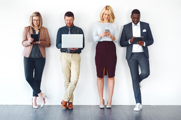 We have all the information needed to succeed. Shot of a group of entrepreneurs using wireless devices against a white background.