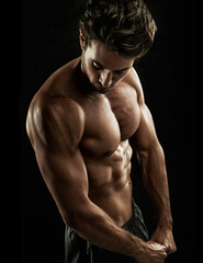 Fototapeta na wymiar Ripped. Muscular young man showing off his defined body.