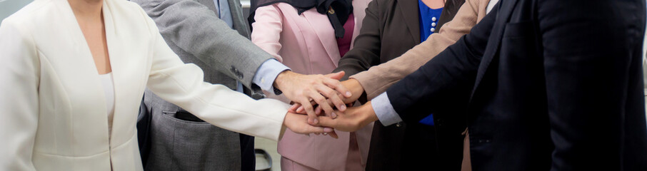 Group of business team harmony with man and woman joining hands stack together in enterprise for victory and success, teamwork of partnership with meeting and cheering, deal and agreement.