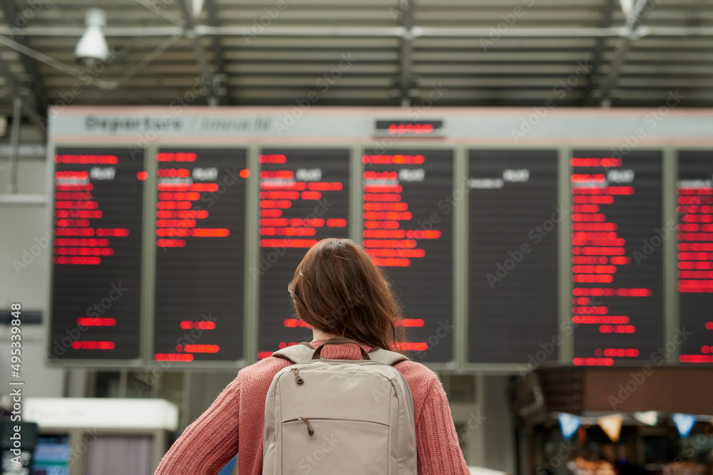 Poster So many flights. Rearview shot of an unrecognizable young woman standing in an airport.