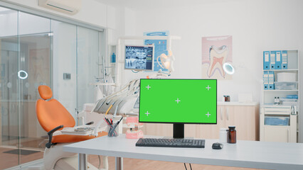 Nobody in dental cabinet with green screen on computer for teethcare. Empty dentist office with isolated background and mockup template on monitor for chroma key. Oral care and dentition