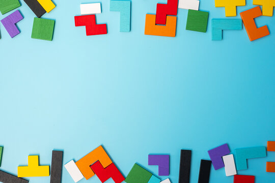 colorful wood puzzle pieces on blue background, geometric shape block with copy space. Concepts of logical thinking, Conundrum, solutions, rational, strategy, world logic day and Education