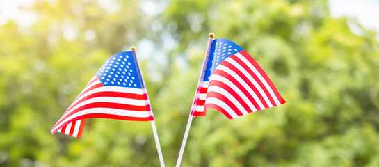 hand holding United States of America flag on green background. USA holiday of Veterans, Memorial, Independence ( Fourth of July) and Labor Day concept