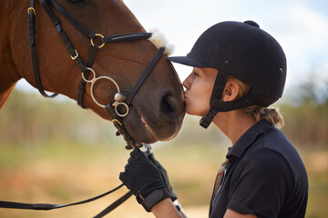 There is a bond between horse and rider. A young female rider being affectionate with her chestnut...