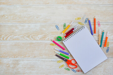 a set of stationery and a white sheet of paper for copy text, a background of school accessories for study, multi-colored felt-tip pens and pencils, scissors and paper clips, stationery childrens