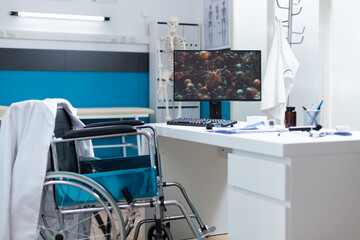 Computer with virus cell image on screen standing on table in empty office room during covid19 global pandemic. Hospital room equipped with professional medical instruments. Coronavirus illustration