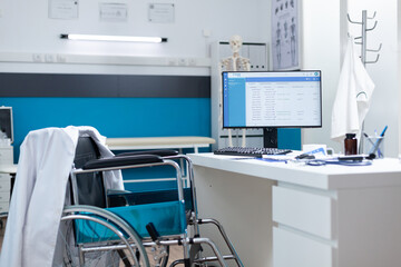 Empty doctor office equipped with medical professional tools ready for disease examination. Computer with patient diagnosis on screen standing on table. Health care support services