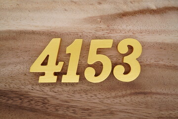 Golden Arabic numerals on a real brown and white wooden floor number 4153