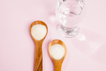 Collagen powder, on a pink background.