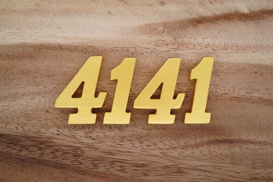 Golden Arabic numerals on a real brown and white wooden floor number 4141