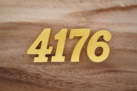Golden Arabic numerals on a real brown and white wooden floor number 4176