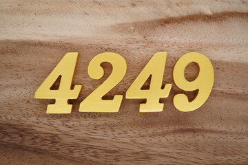Golden Arabic numerals on a real brown and white wooden floor number 4249