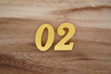 Golden Arabic numerals on a real brown and white wooden floor number 02