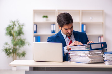 Young male employee unhappy with excessive work in the office