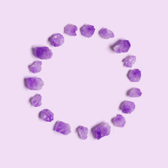 Magic circle of purple amethyst crystals on very peri color background, top view natural beautiful gemstone as round. Amethyst stone healing crystal, creative flat lay, frame from gems